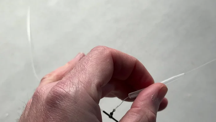 Thread the trace line through the thicker end of the boom and pull it down to the swivel.