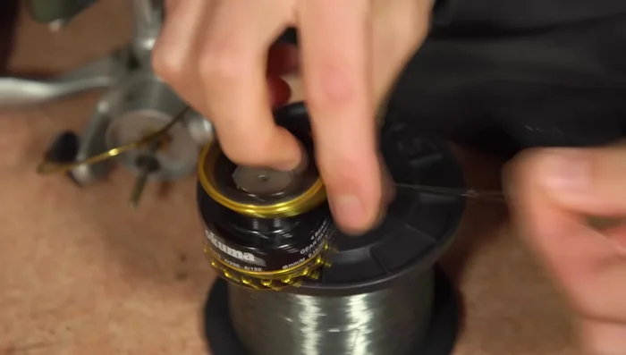 Thread the line through the rod guide and tie it to an empty spool with an arbor knot.