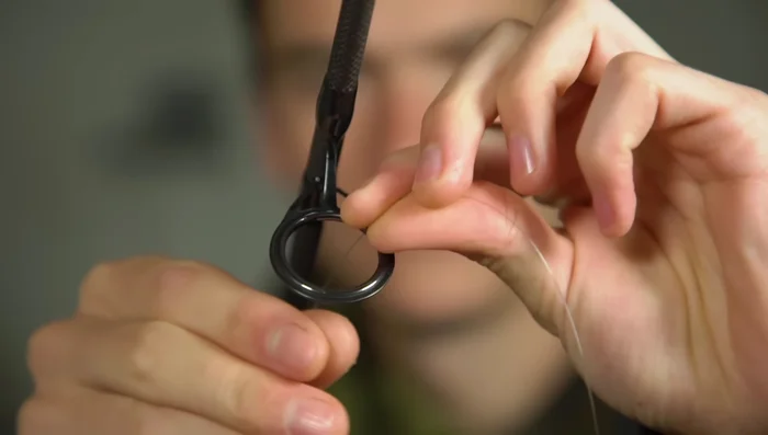 Thread the line backwards through the first eye of the fishing rod.