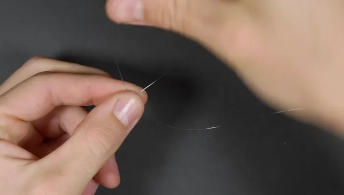 Tie the line to the spool using an arbor knot (two overhand knots). Moisten the knot with saliva.