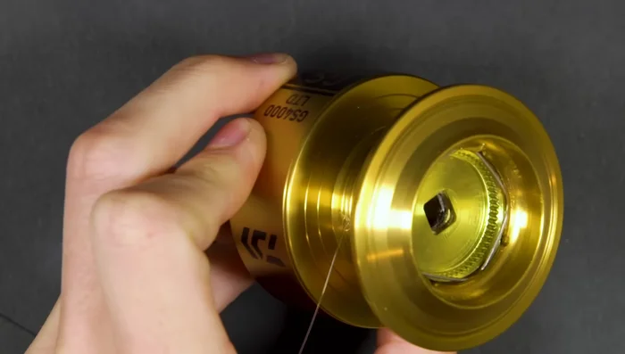 Apply tension to the line and reel it onto the spool until it's almost full (leave a couple of millimeters).