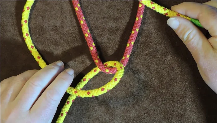 Pass the netting needle underneath both red lines (loops).