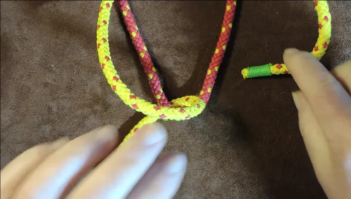 Pass the netting needle underneath both red lines (loops).