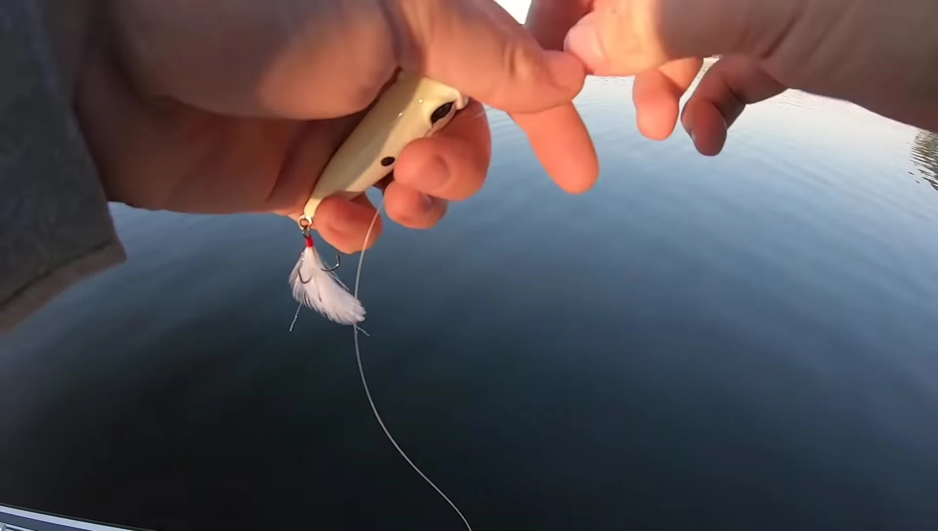 Close-up of monofilament line being tied to a fishing lure