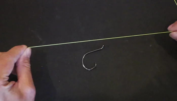 Pinch the line against the hook to hold it in place.