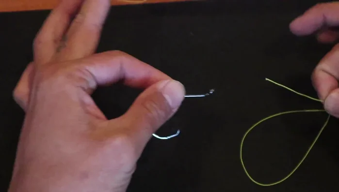 Pinch the line against the hook to hold it in place.