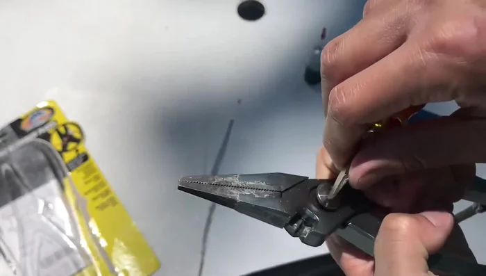 Pull apart the pliers to access the spring and washer.