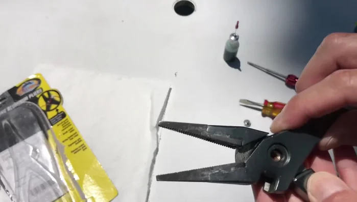 Pull apart the pliers to access the spring and washer.