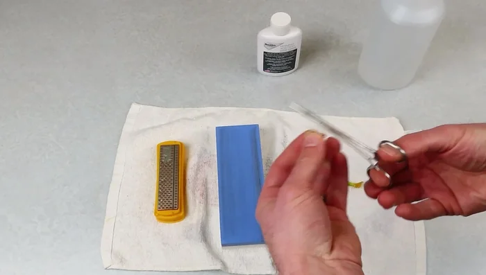 Rub the hook against the sanding block.