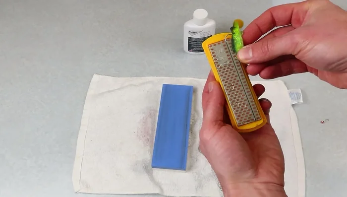 Place the hook point into the groove of the sharpening stone.