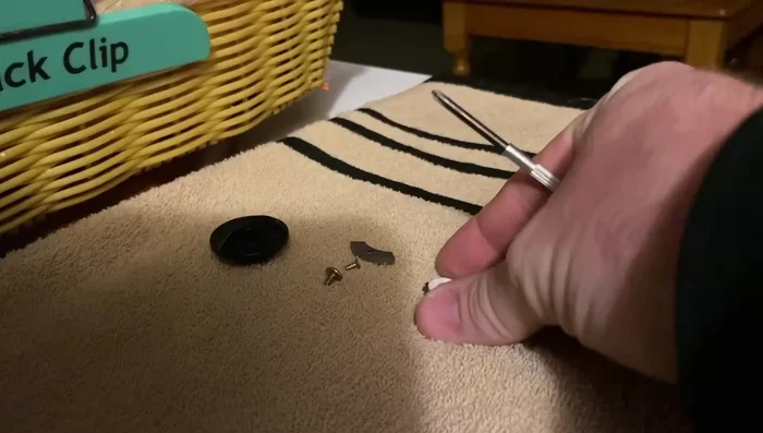 Remove the remaining screws and parts, keeping track of their order on the towel.