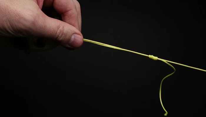 Give a light pull on the end of the line, then switch to the main line and pull firmly to tighten the knot.