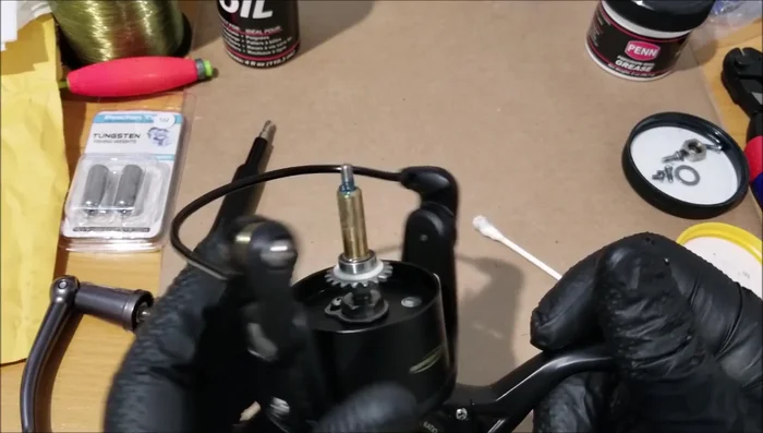 Inspect the bail for sand in the grooves. If sand is present and causes grinding, remove the screw to clean.