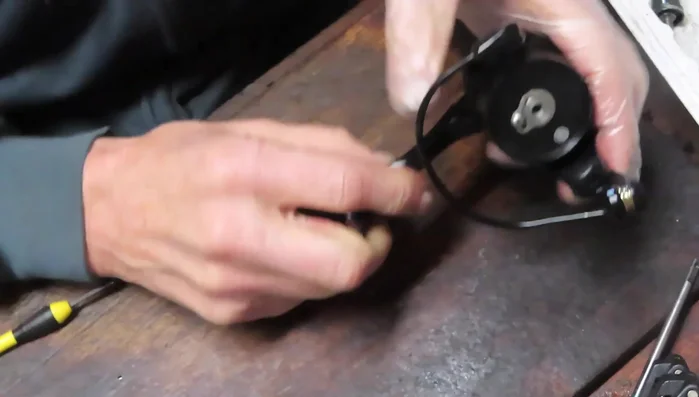 Grease the axle shaft and insert it through the pinion gear and bushing. Secure with a screw.