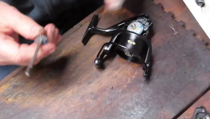 Grease the axle shaft and insert it through the pinion gear and bushing. Secure with a screw.