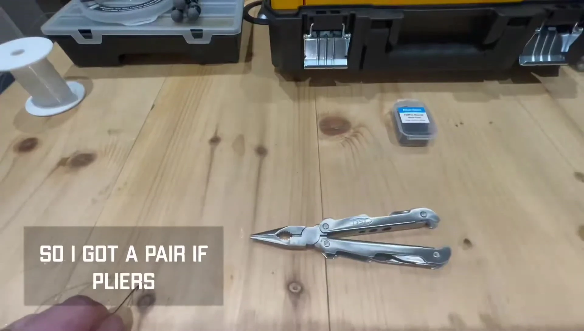 Pliers being used to test the bend of a cheap Aberdeen hook.