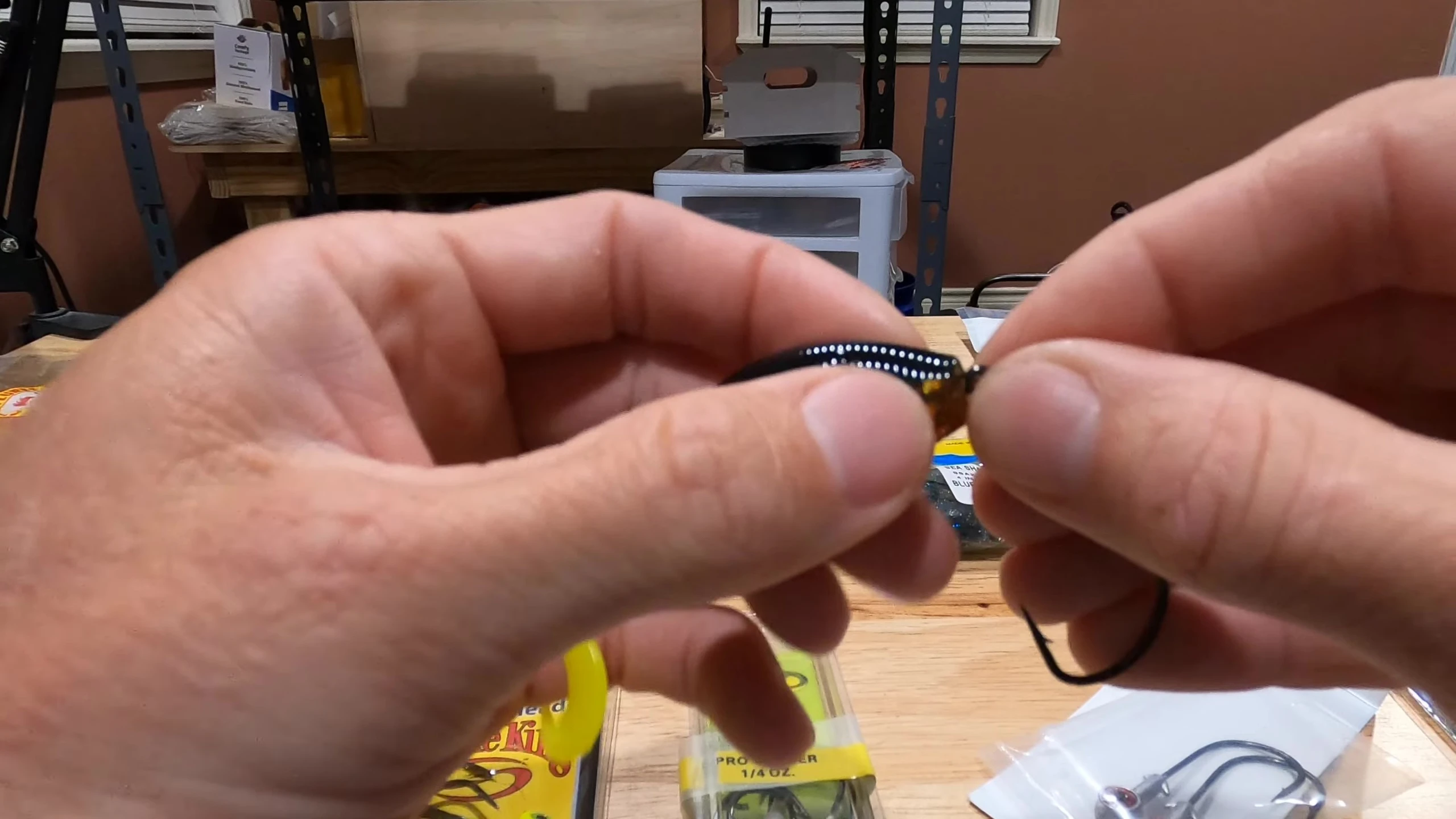 A close up of various weedless swim bait hooks