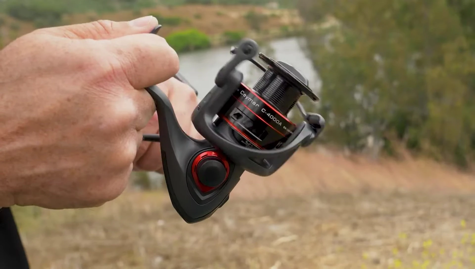 Someone turning the handle of the Okuma Ceymar A reel to demonstrate its smooth operation.
