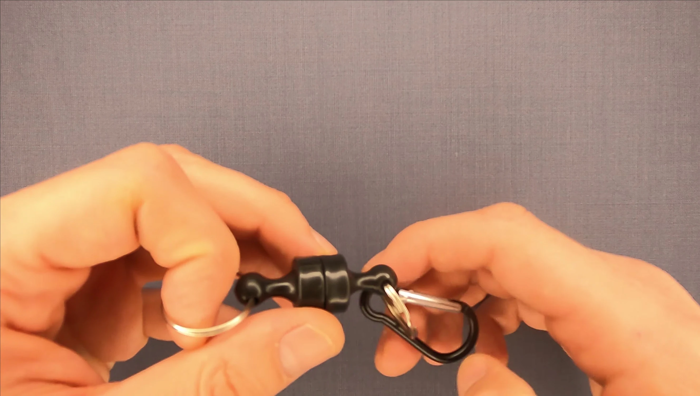 The reviewer showing the tool attached to a keychain and illustrating versatility beyond fishing.