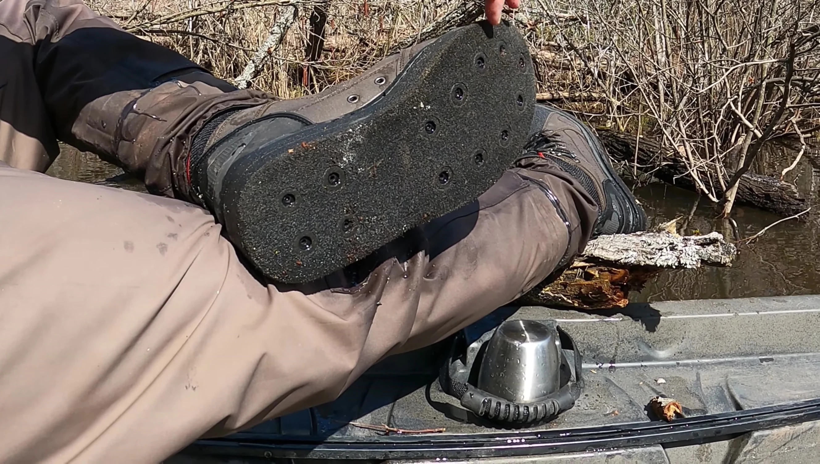 The reviewer showing the studs and the system for attaching them to the sole of the boots.