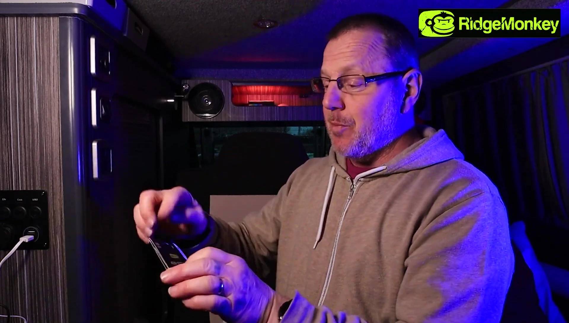 Close-up of the presenter trying on the gloves, highlighting the sizing issue.