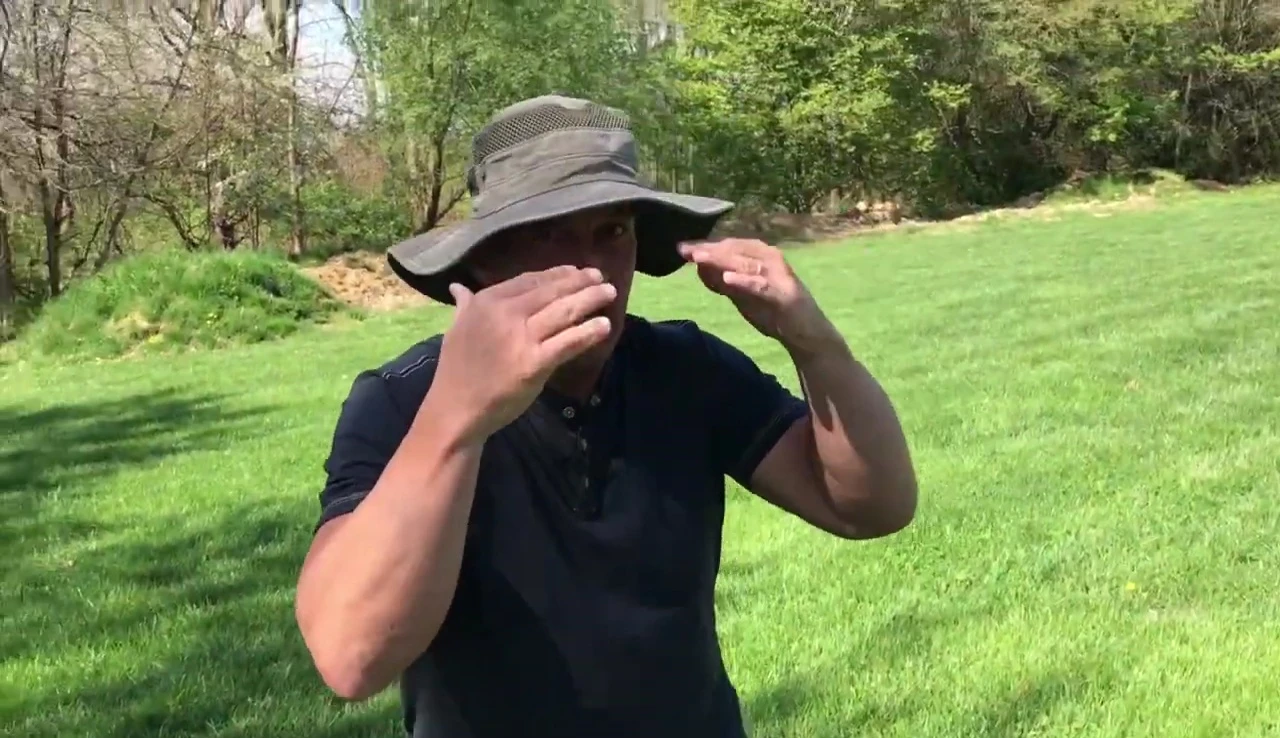 The speaker demonstrating the hat's coverage.