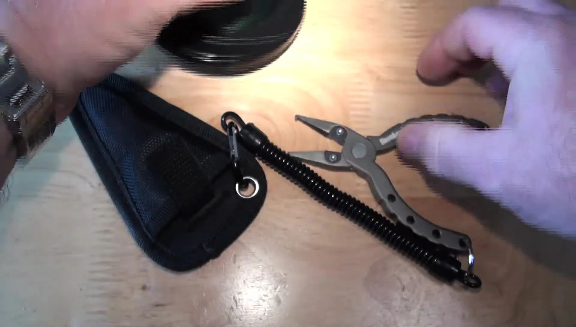 The reviewer attempting to cut braid with the Snowbee pliers