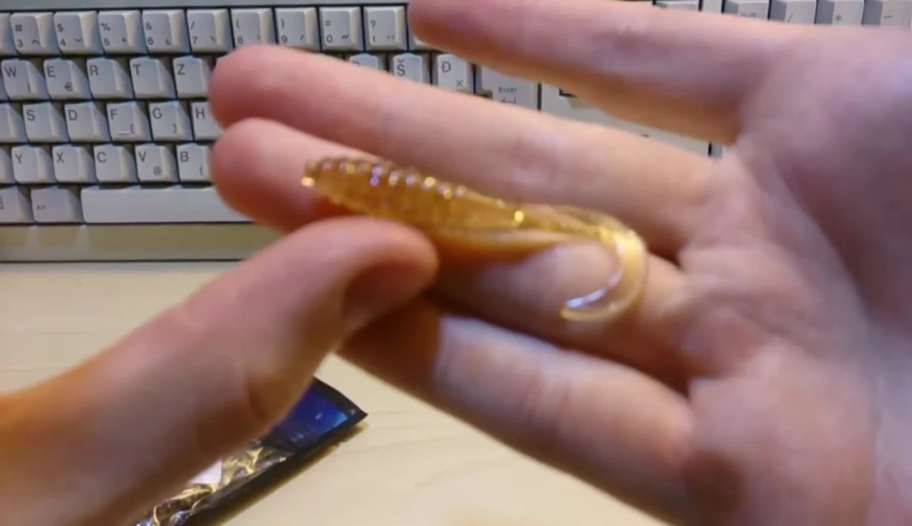 The reviewer holding up one of the glitter worm baits.