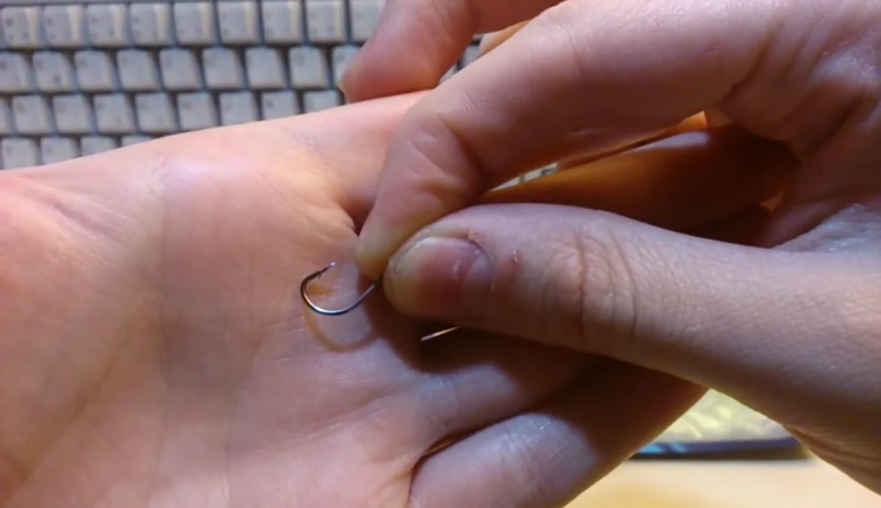 Close-up of a single fish hook, highlighting its sharpness and barbs.
