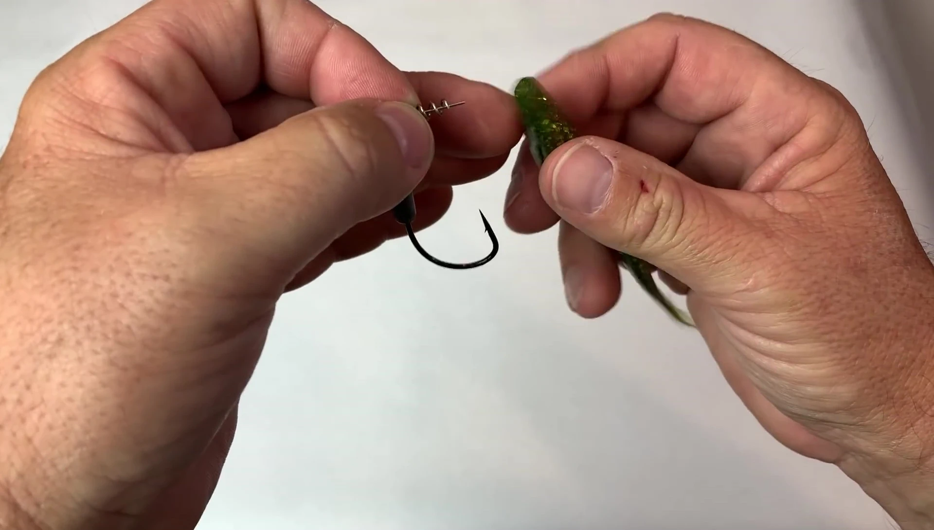 Demonstrating the insertion of the center pin into the soft plastic lure.