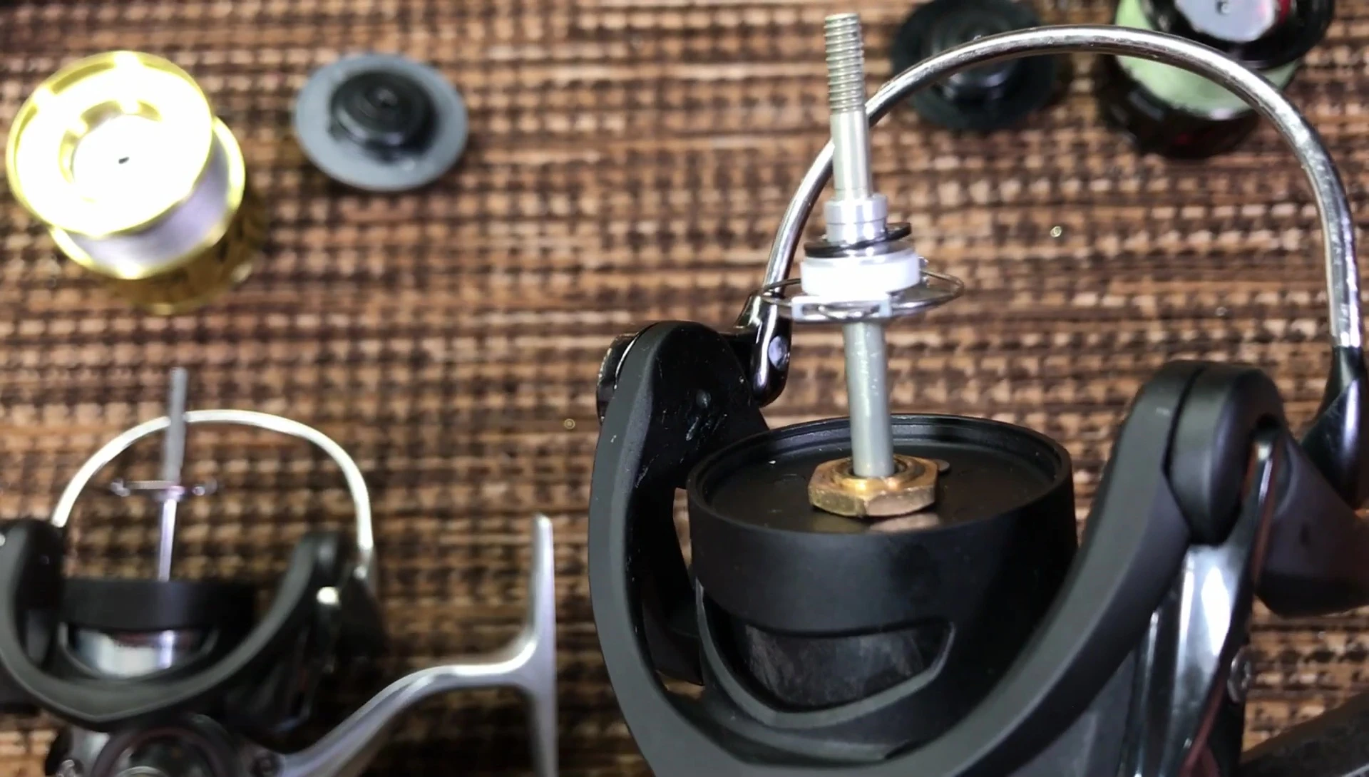 Presenter points at the colored plastic under the spool of the Tatula LT