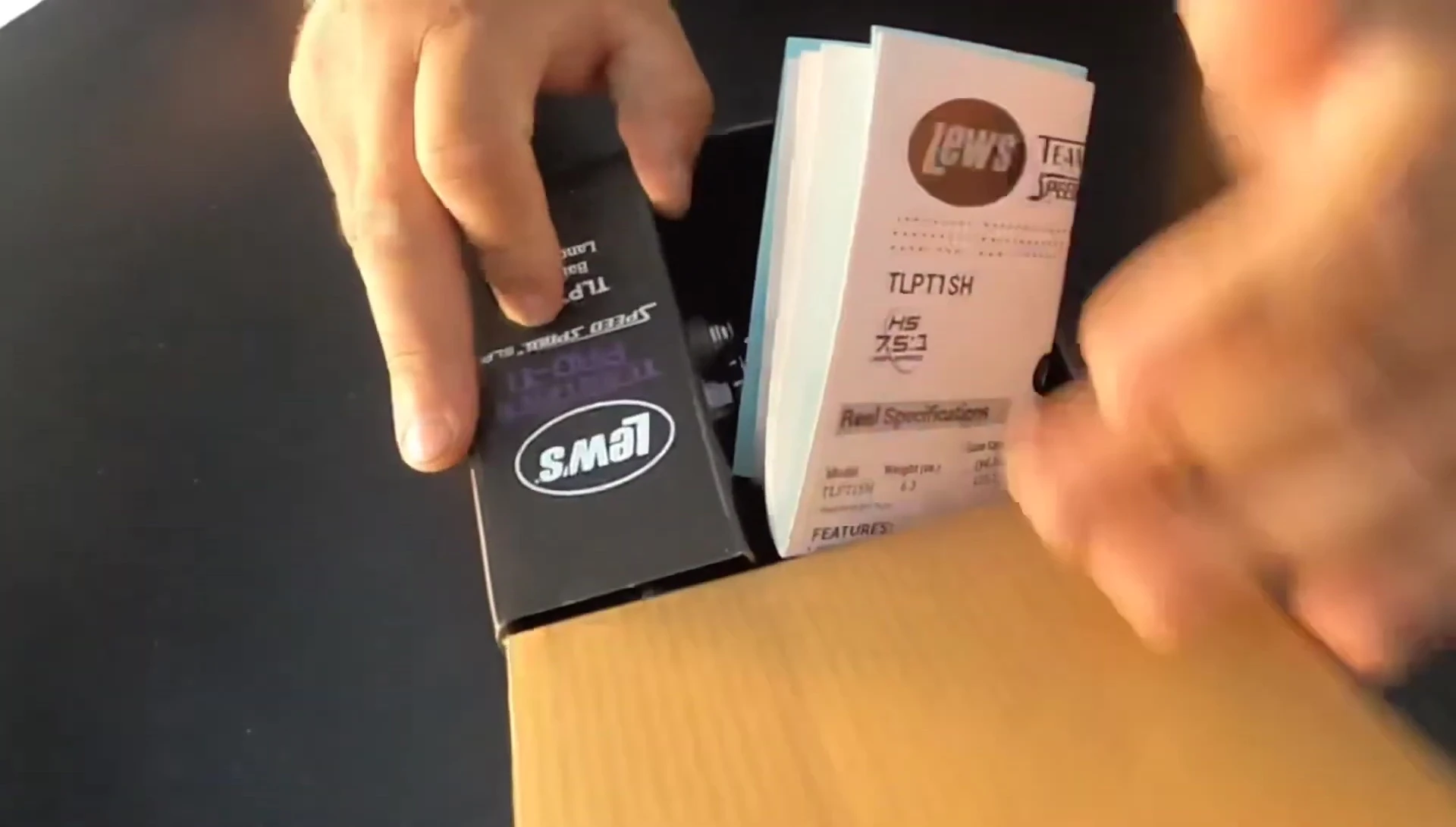 Unboxing the Lews Pro-Ti reel, showing the contents.