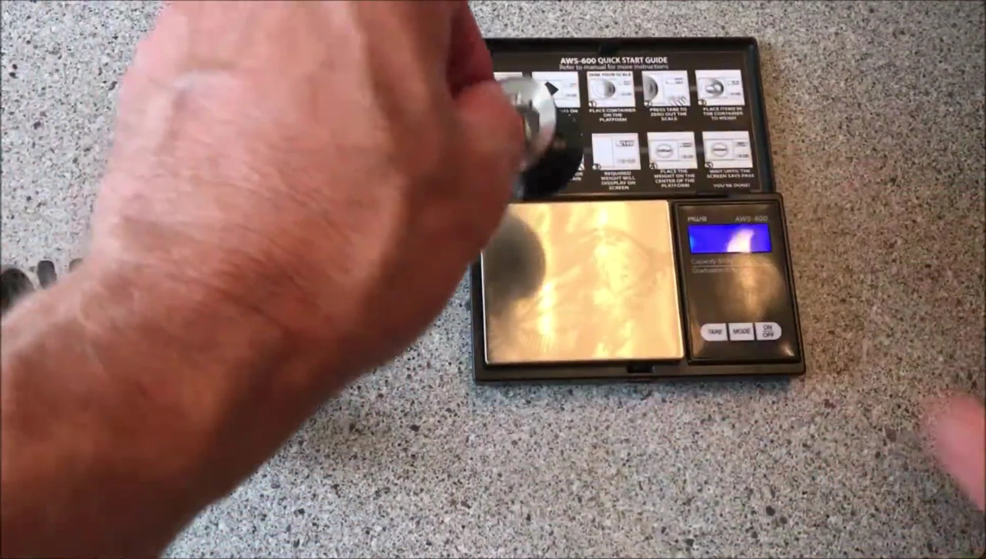 The reel being weighed on a scale.