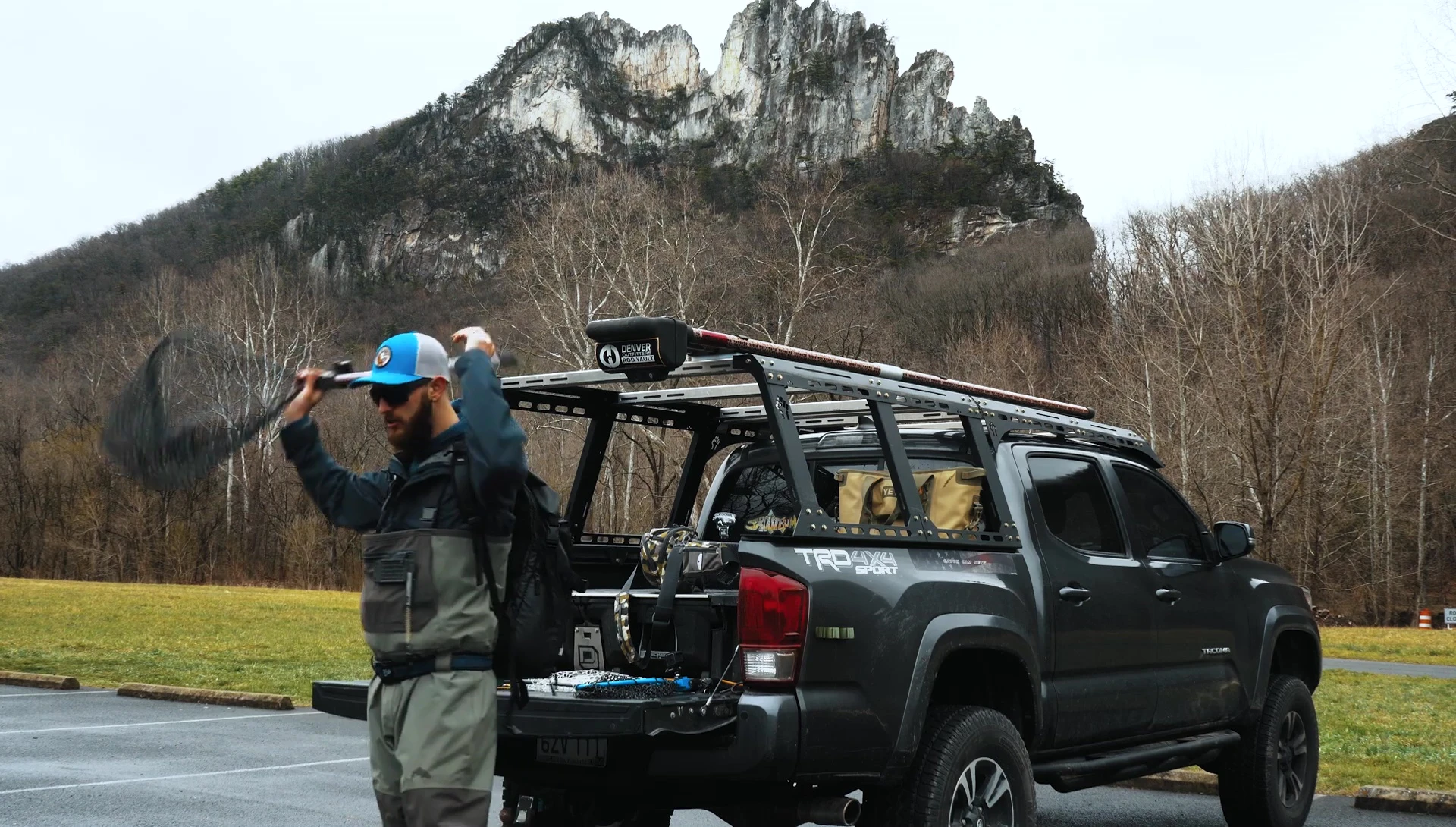 Carrying a large fishing net in a backpack with the handle sticking out.