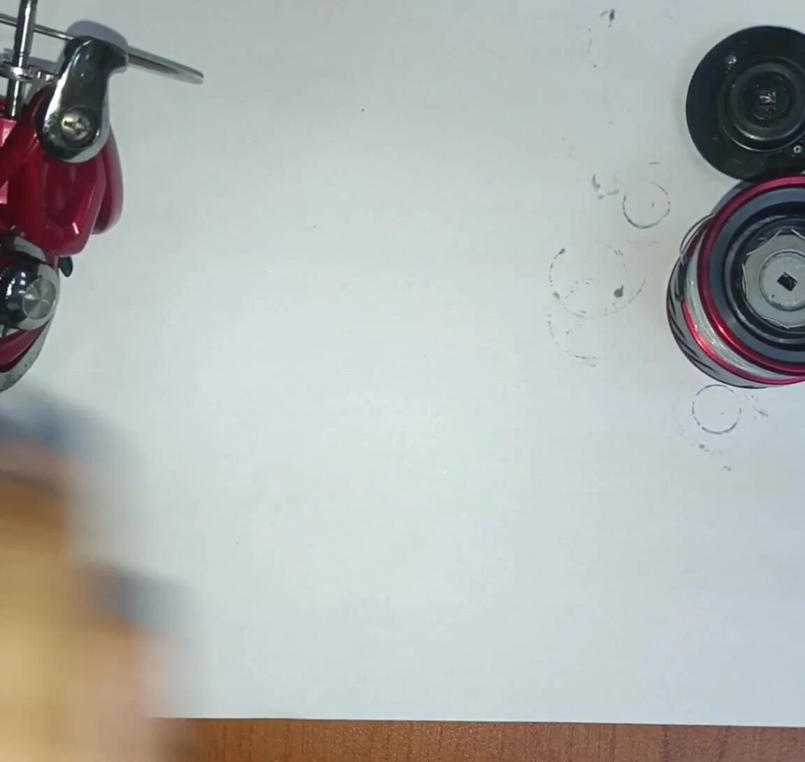 The reel in the presenter's hand, emphasizing its lightweight feel.