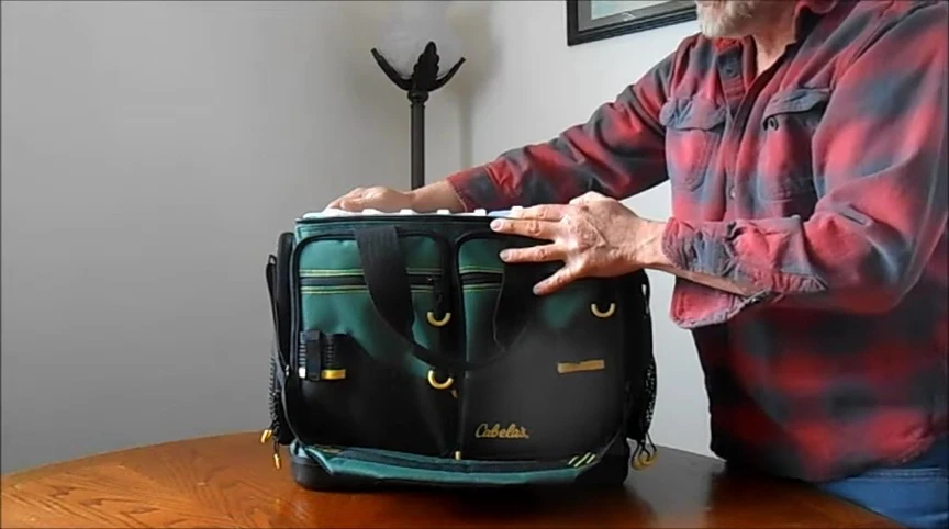 The reviewer showcasing a section of the tackle box for fishing.