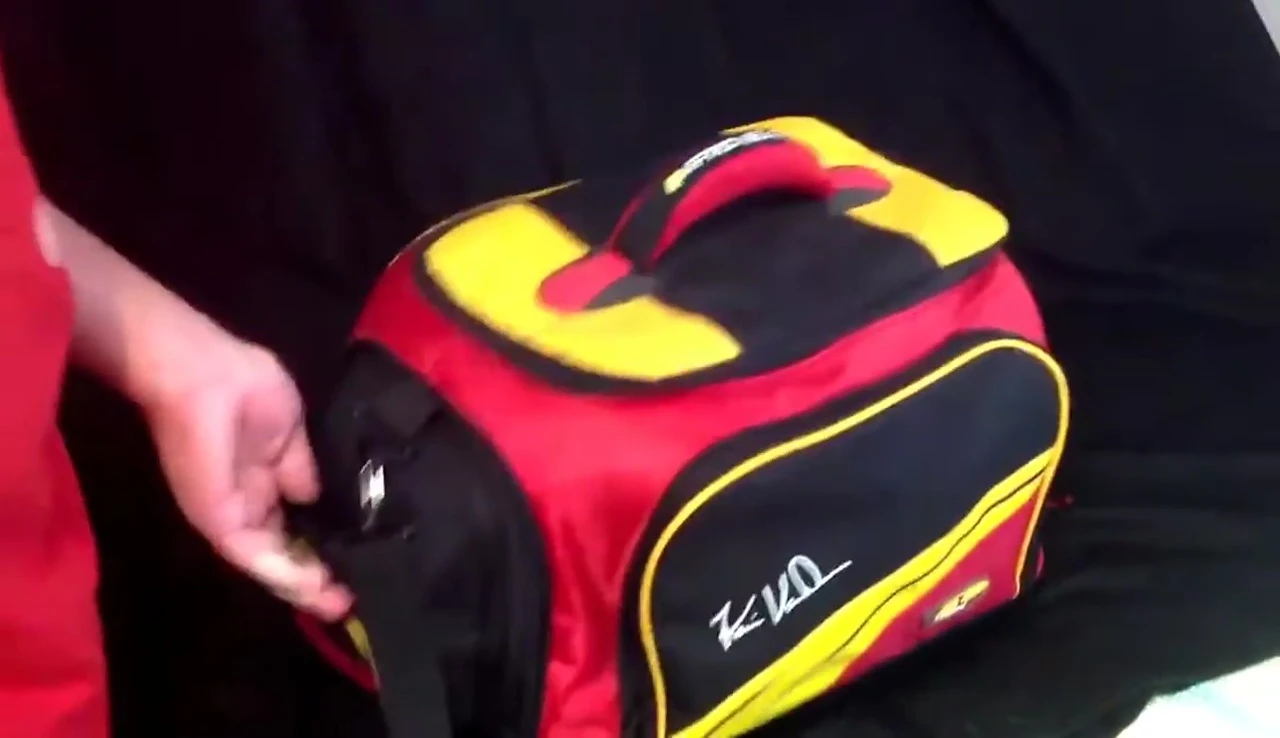 The angler demonstrates how to easily lift the Plano FTO Elite Series Tackle Bag using the side handles.