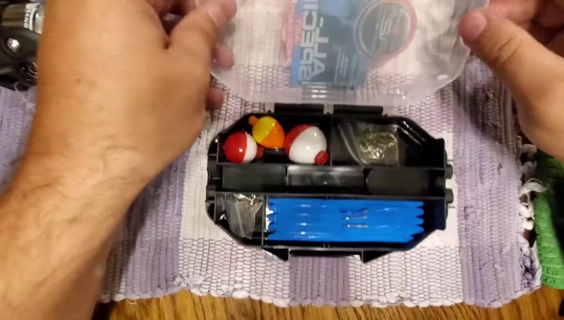 The small tackle box being opened to showcase its contents