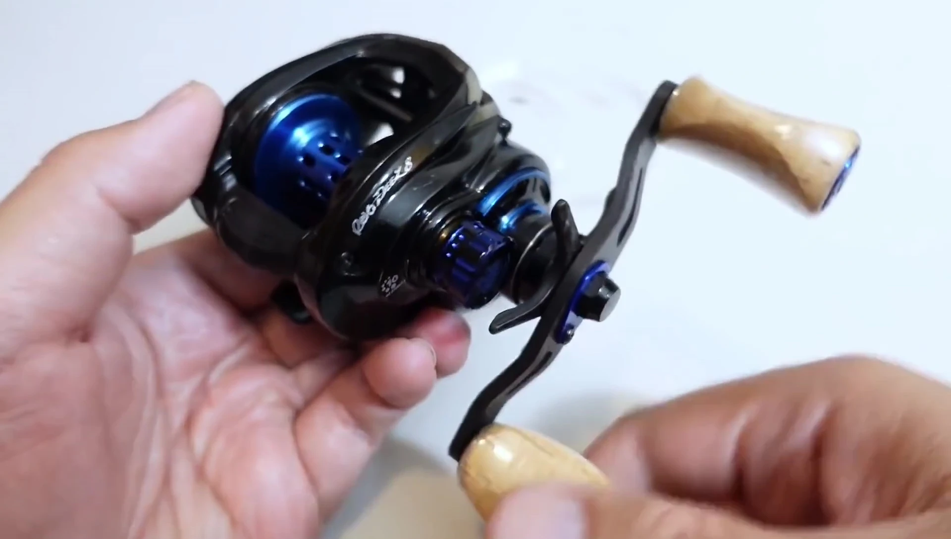 Close-up of the Revo DS8 reel, showcasing its black body and blue and chrome accents.