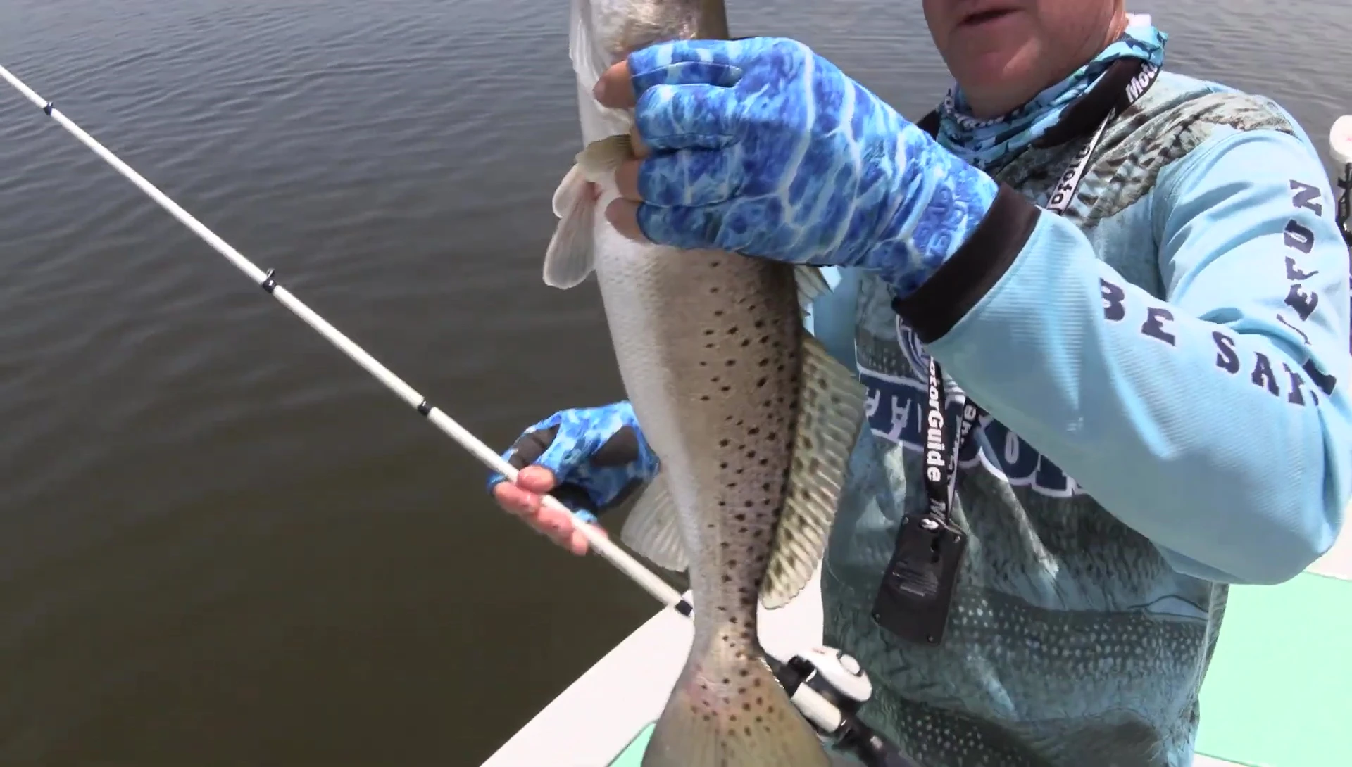 Close-up of the speaker's hands wearing Glacier Gloves while handling a fish.