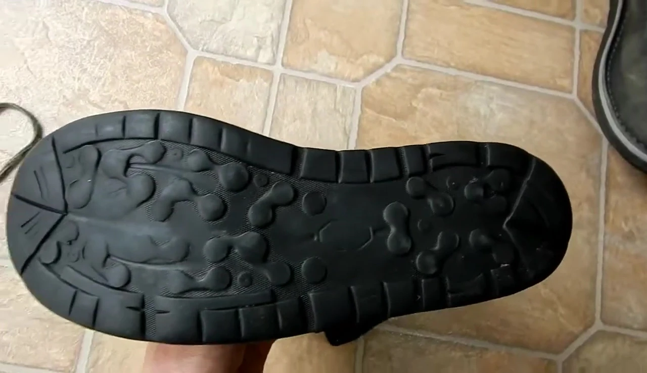 Close-up shot of the worn-down soles showing significant lug wear.