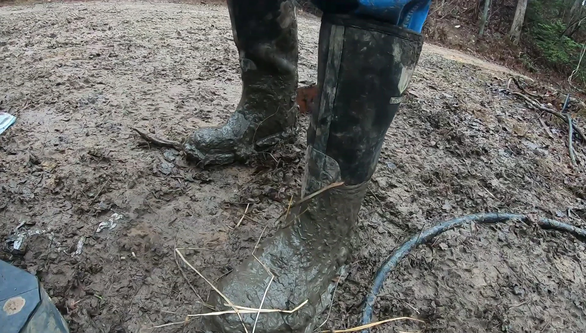The reviewer shows off the boots after a week of use, highlighting the mud.