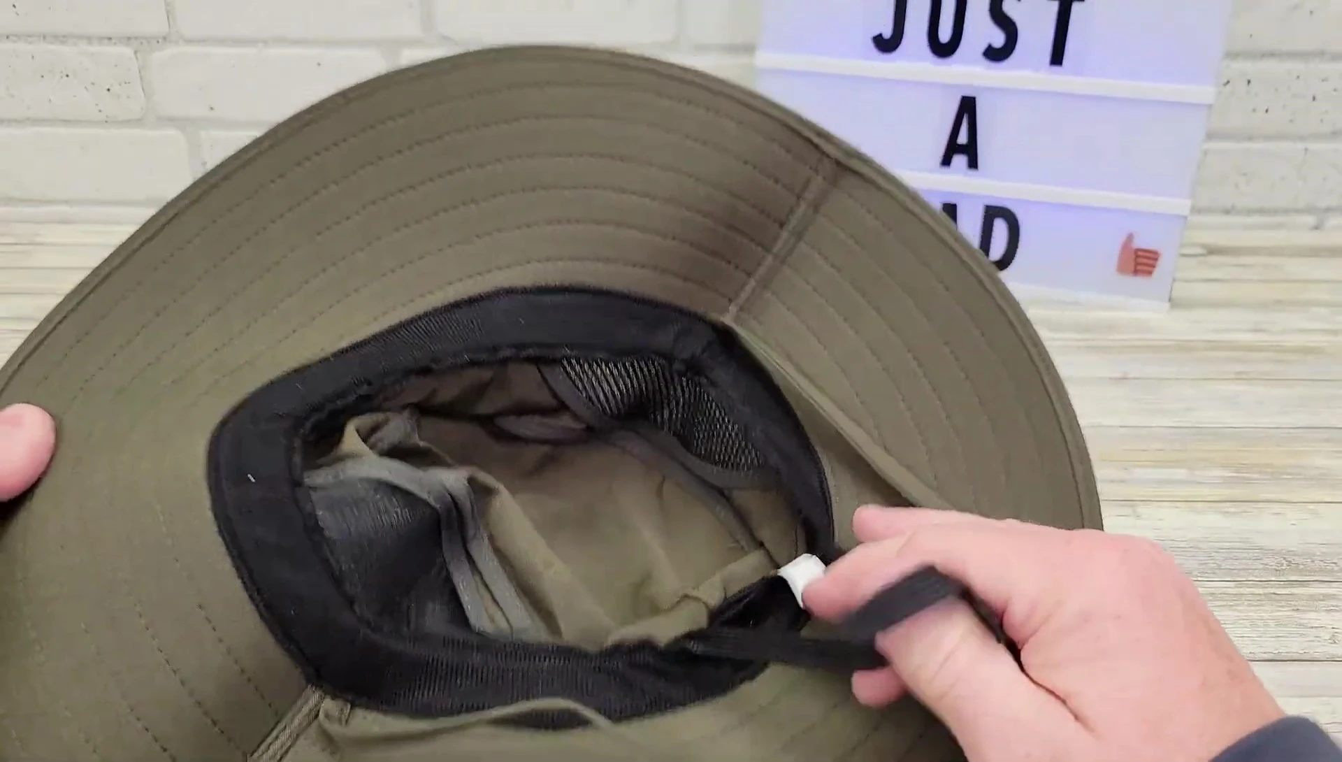 Close-up shot of the hat on the reviewer's head, highlighting the adjustable features.