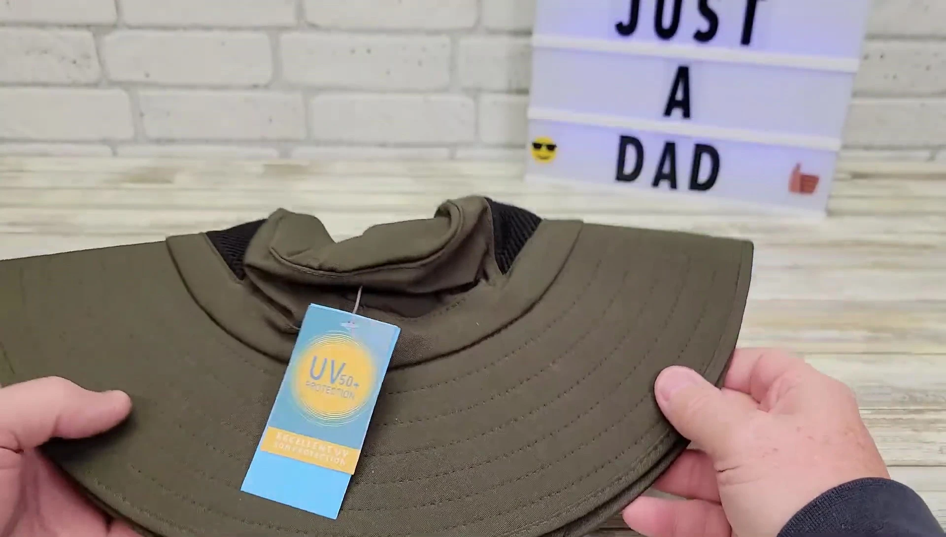 The reviewer demonstrates folding the hat.