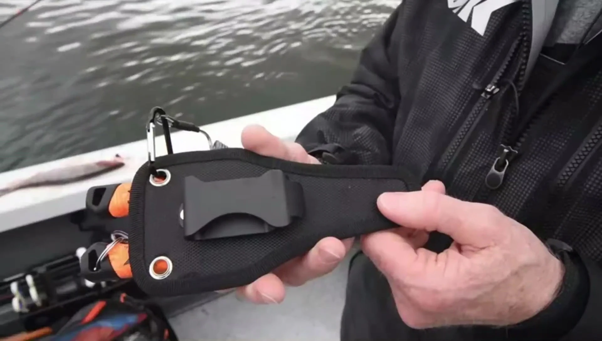 The swivel clip and lanyard attachment points on the sheath.