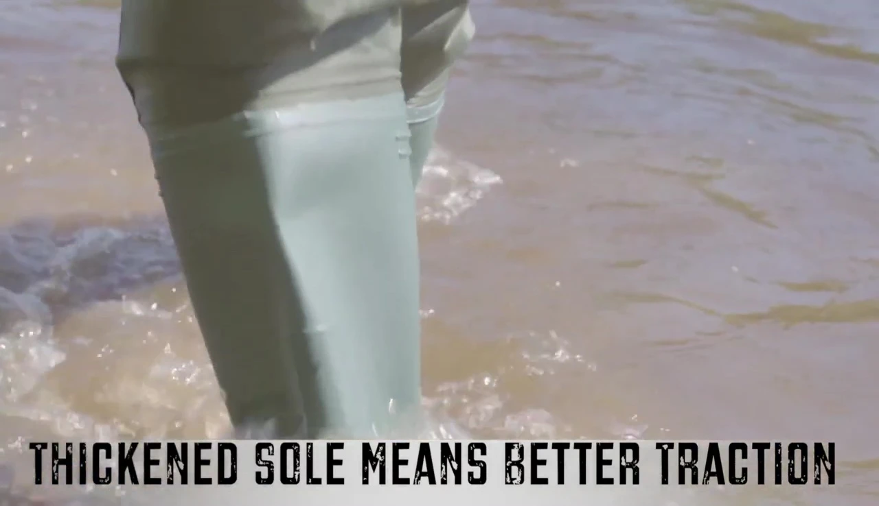 Person wearing the waders walking through water, showcasing the sole's grip.