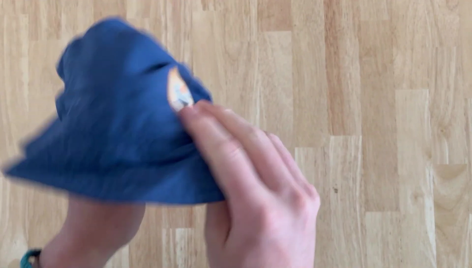 The speaker demonstrating how to fold the hat.