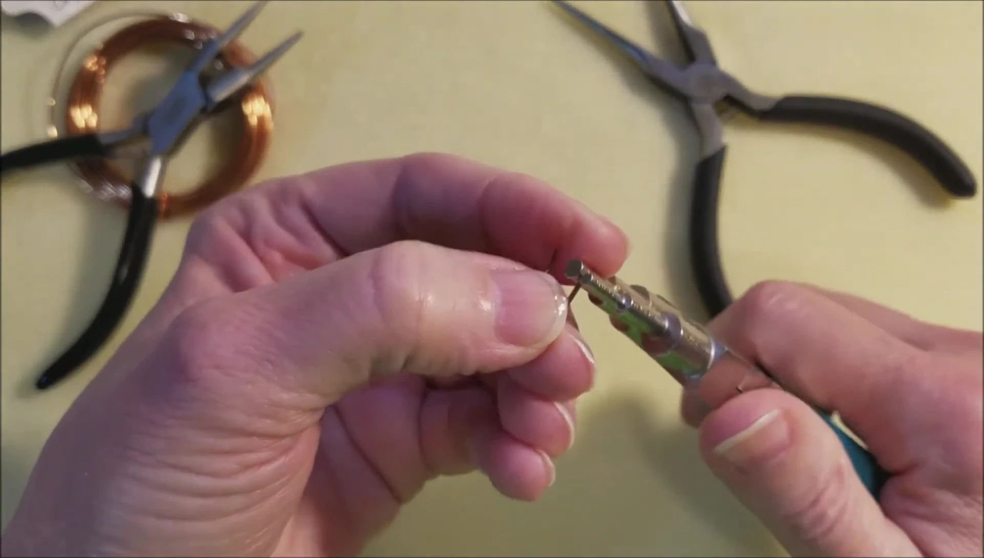 Using round-nose pliers to create the loop.